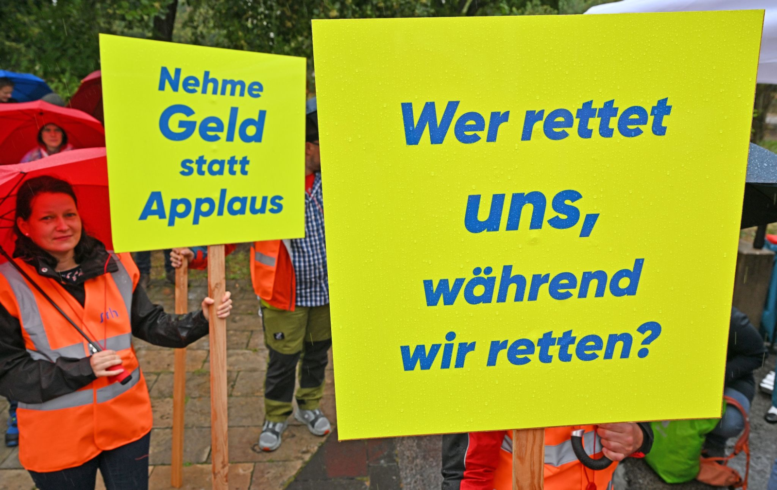 Mitarbeiter stehen bei einer Kundgebung unter dem Motto "Alarmstufe Rot: Krankenhäuser in Gefahr!" vor dem Thüringer Landtag.