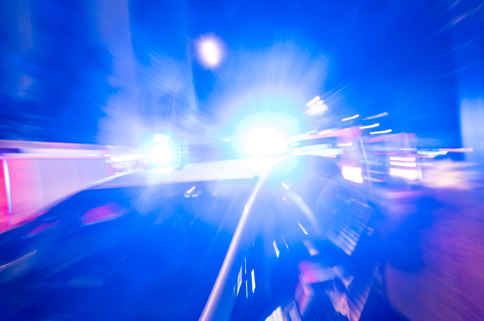 Ein Streifenwagen der Polizei steht mit Blaulicht an einem Einsatzort.