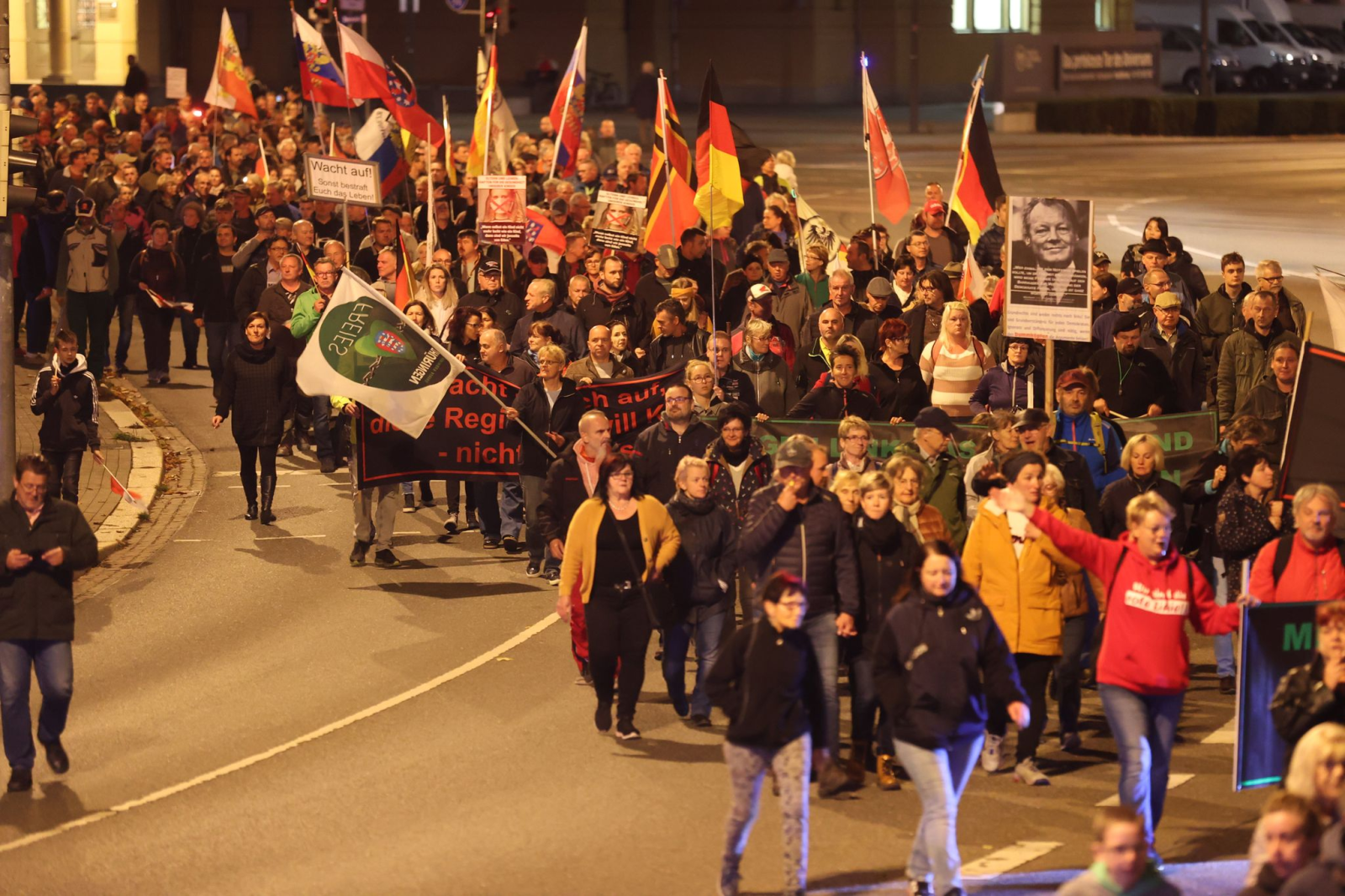 Teilnehmer einer Demonstration gegen die Energiepolitik der Bundesregierung und gegen Coronamaßnahmen laufen am Abend durch die Innenstadt.