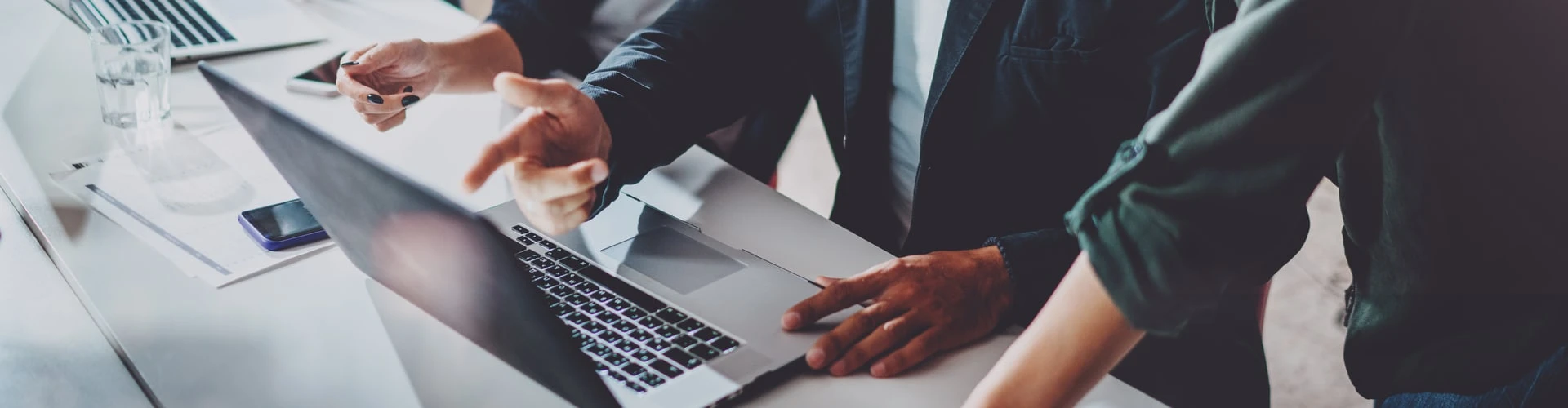 Menschen stehen vorm Laptop und zeigen mit dem Finger dadrauf, © Shutterstock Menschen stehen vorm Laptop und zeigen mit dem Finger dadrauf, © Shutterstock