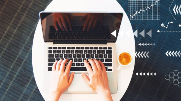 Hände mit Laptop auf Tisch aus Vogelperspektive, © shutterstock