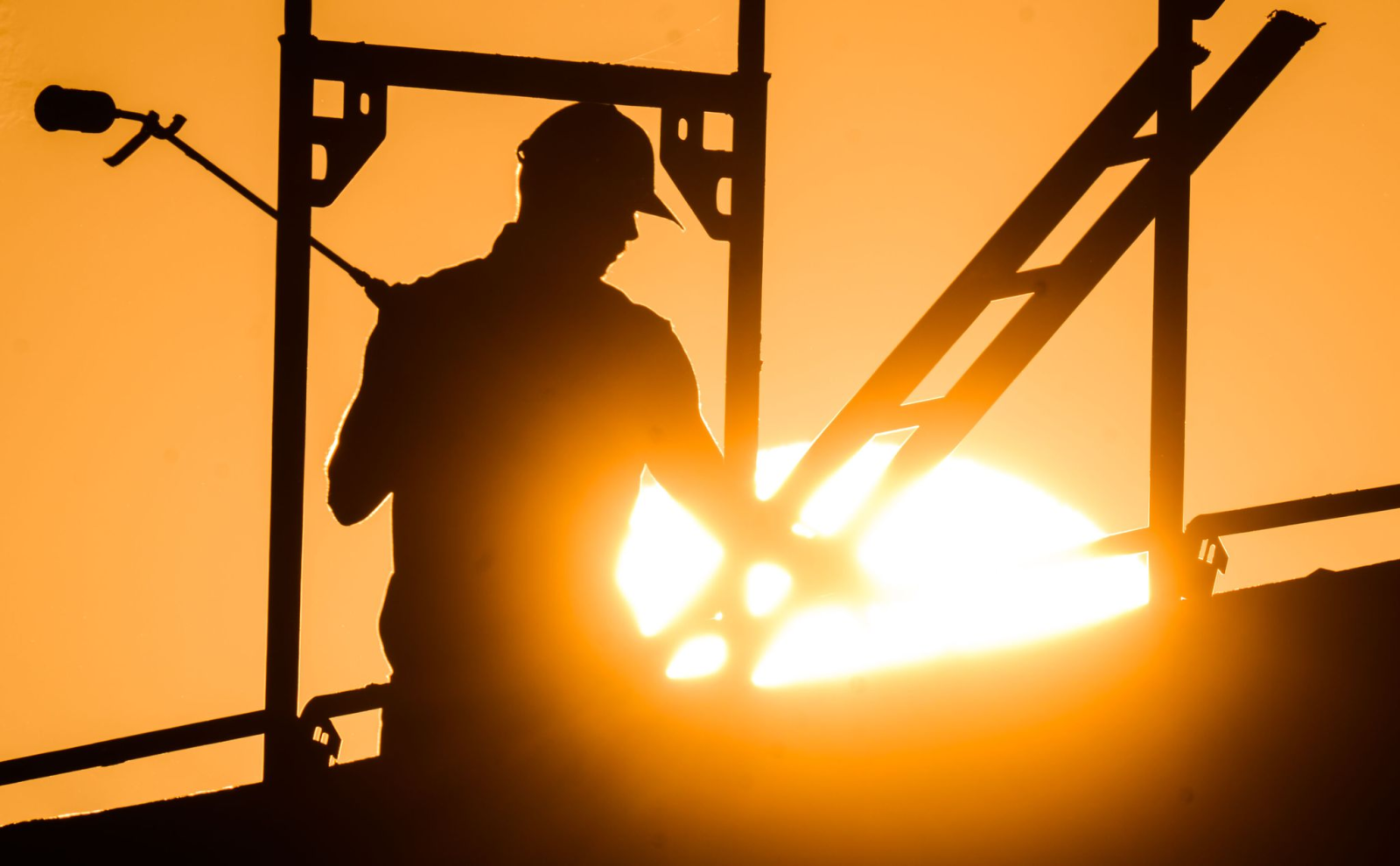 Ein Bauarbeiter mit einem Gasbrenner beim Bau eines Mehrfamilienhauses.