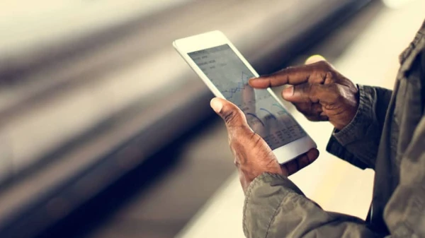 Frau am Gleis mit einem Smartphone in der Hand. Nur die Hände und das Gleis zu sehen, © Shutterstock Frau am Gleis mit einem Smartphone in der Hand. Nur die Hände und das Gleis zu sehen, © Shutterstock
