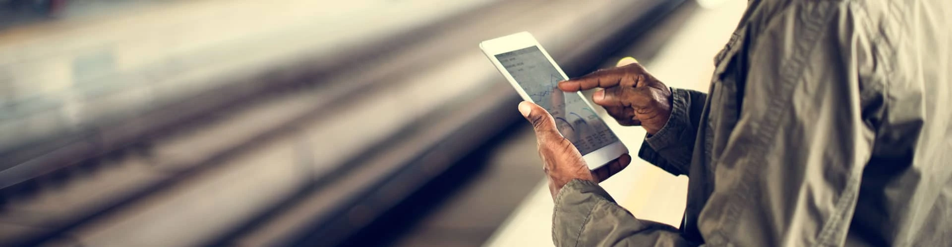 Frau am Gleis mit einem Smartphone in der Hand. Nur die Hände und das Gleis zu sehen, © Shutterstock Frau am Gleis mit einem Smartphone in der Hand. Nur die Hände und das Gleis zu sehen, © Shutterstock
