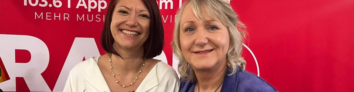 Zwei Frauen vor roter Wand, © Shutterstock